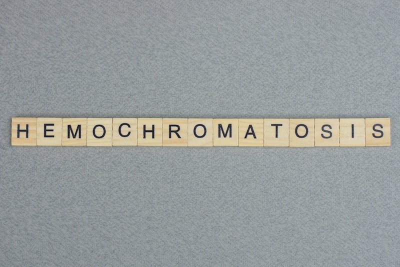text the word hemochromatosis from brown wooden small letters with black font on an gray table